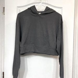 Jersey/soft fleece material. Cropped hoodie long sleeve. New, size xs. Dark gray